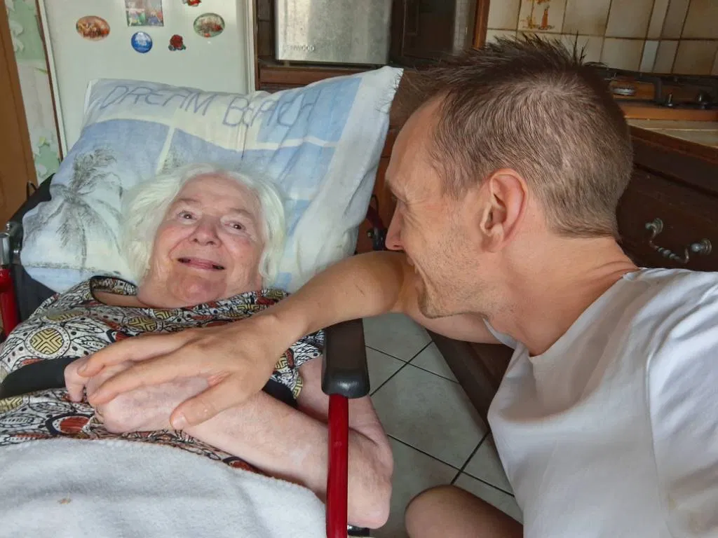 Christophe with his mother, who is smiling at him
